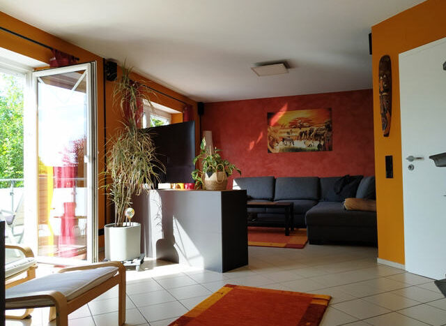 Offener Wohnbereich mit Zugang zum Balkon